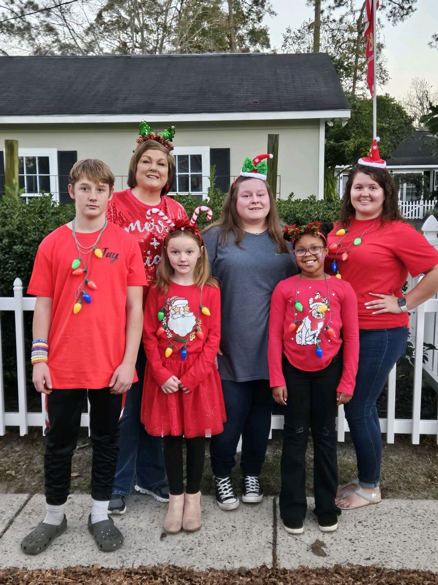 Kim and group of people wearing red christmas shirts 