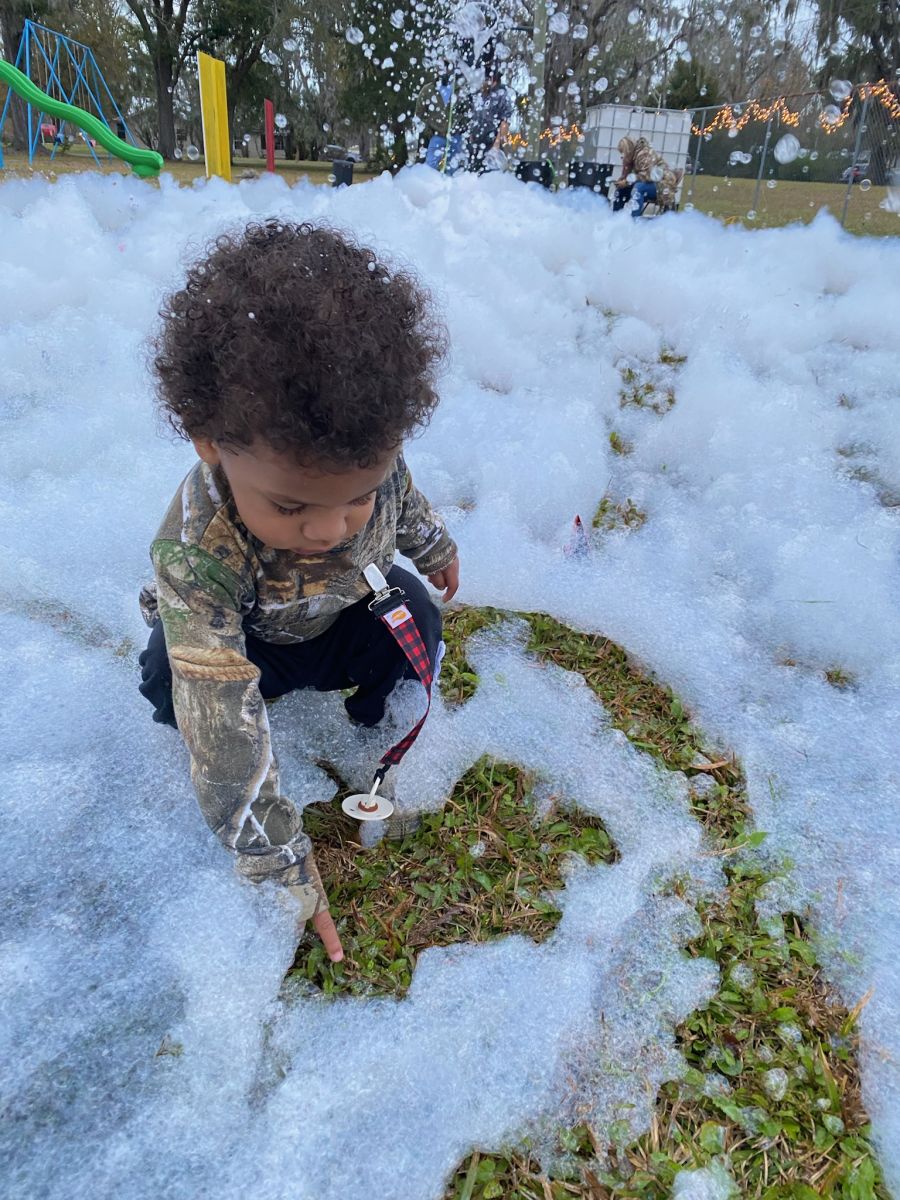 child playing at park in snow foam
