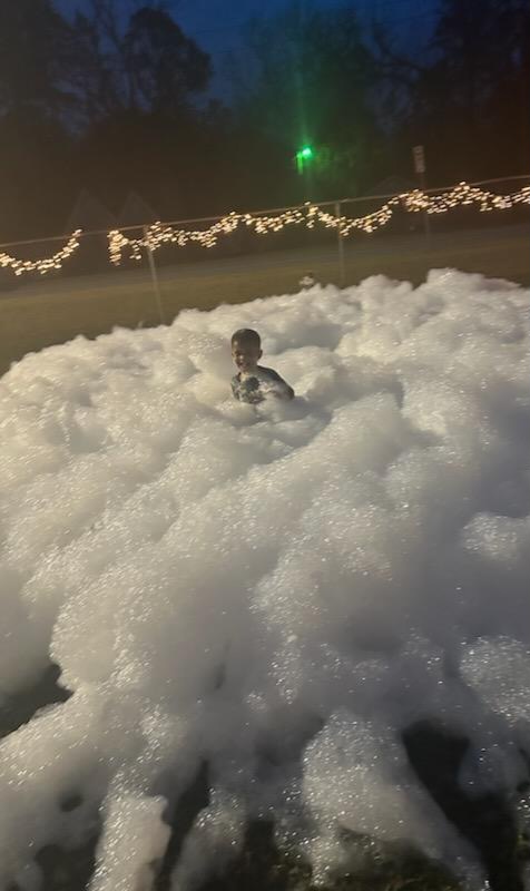 kid playing in snow foam at park event